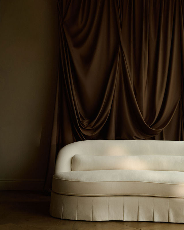 Reign sofa in front of a large brown curtain